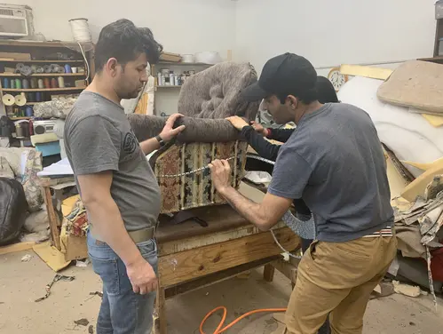 works repairing upholstery on a chair