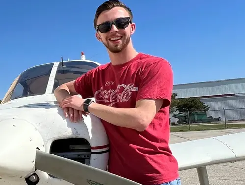 Anthony Reyman leaning on an airplane.