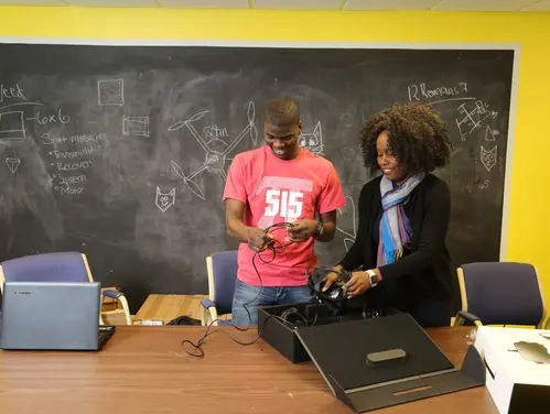 Nancy helps student in front of a chalkboard.