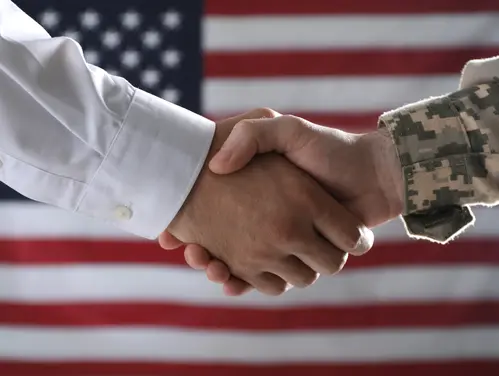 An image of a handshake in front of an American flag