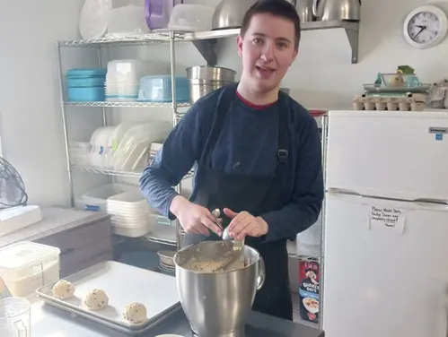 Isaac Ruow scooping batter onto cookie sheets