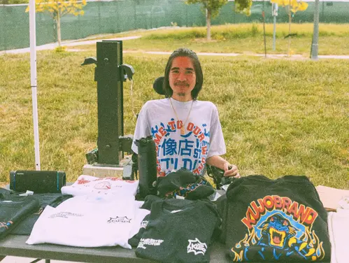 Kevin Ha behind a table displaying his product offering.