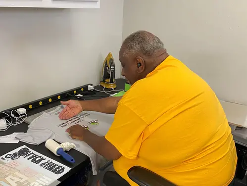 Maurice Nurse putting the finishing touches on a shirt