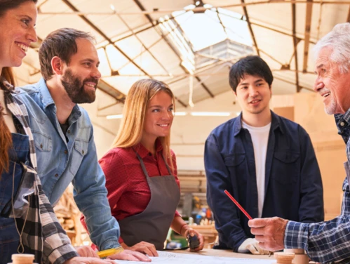 A photo of a work-based learning situation where an older individual is instructing students in the workplace