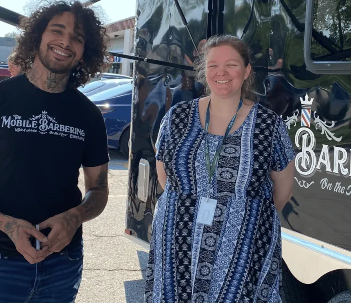A program participant in the Pre-Employment Transition Services program poses for a photo with a business leader. This was during the "Shark Tank" portion of the program where participants create business ideas and share them with business leaders.