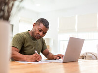 Service Member Taking Notes at a Computer