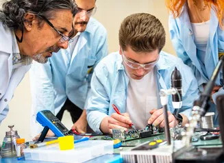 A males student learns how to assemble computer parts during his internship