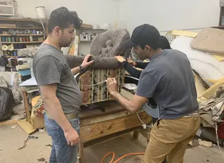 works repairing upholstery on a chair