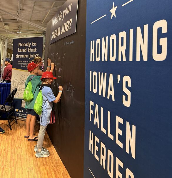 Young Iowans Writing on the Chalkboard at the Iowa Workforce Development Fair Booth